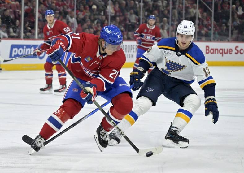 Feb 11, 2024; Montreal, Quebec, CAN; Montreal Canadiens defenseman Kaiden Guhle (21) plays the puck and St.Louis Blues forward Alexey Toropchenko (13) forechecks during the first period at the Bell Centre. Mandatory Credit: Eric Bolte-USA TODAY Sports