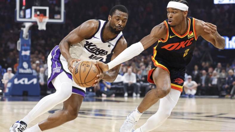 Feb 11, 2024; Oklahoma City, Oklahoma, USA; Oklahoma City Thunder guard Shai Gilgeous-Alexander (2) reaches to steal the ball from Sacramento Kings forward Harrison Barnes (40) during the first quarter at Paycom Center. Mandatory Credit: Alonzo Adams-USA TODAY Sports