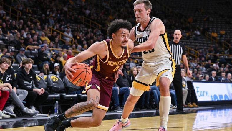 Feb 11, 2024; Iowa City, Iowa, USA; Minnesota Golden Gophers guard Braeden Carrington (4) goes to the basket as Iowa Hawkeyes forward Payton Sandfort (20) defends during the first half at Carver-Hawkeye Arena. Mandatory Credit: Jeffrey Becker-USA TODAY Sports