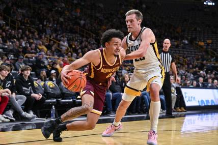 Feb 11, 2024; Iowa City, Iowa, USA; Minnesota Golden Gophers guard Braeden Carrington (4) goes to the basket as Iowa Hawkeyes forward Payton Sandfort (20) defends during the first half at Carver-Hawkeye Arena. Mandatory Credit: Jeffrey Becker-USA TODAY Sports