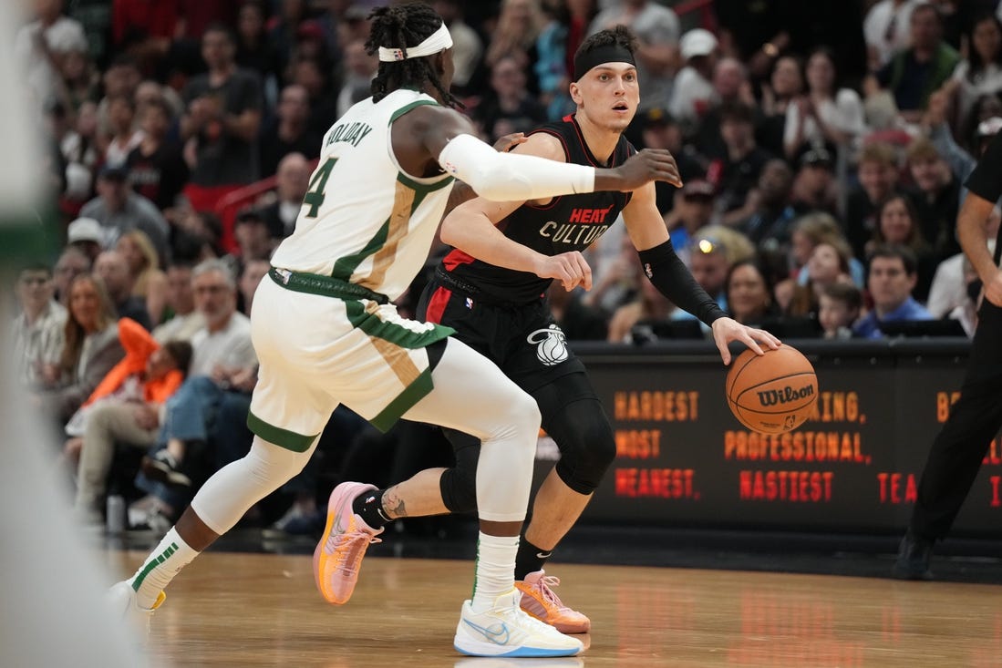 Feb 11, 2024; Miami, Florida, USA;  Miami Heat guard Tyler Herro (14) dribbles the ball against Boston Celtics guard Jrue Holiday (4) defends during the second half at Kaseya Center. Mandatory Credit: Jim Rassol-USA TODAY Sports