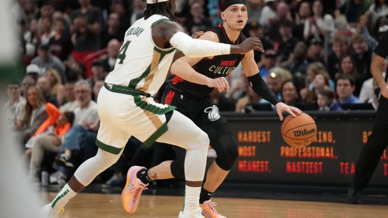 Feb 11, 2024; Miami, Florida, USA;  Miami Heat guard Tyler Herro (14) dribbles the ball against Boston Celtics guard Jrue Holiday (4) defends during the second half at Kaseya Center. Mandatory Credit: Jim Rassol-USA TODAY Sports