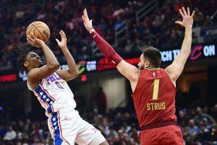 Feb 12, 2024; Cleveland, Ohio, USA; Philadelphia 76ers guard Tyrese Maxey (0) shoots over the defense of  Cleveland Cavaliers guard Max Strus (1) during the first half at Rocket Mortgage FieldHouse. Mandatory Credit: Ken Blaze-USA TODAY Sports