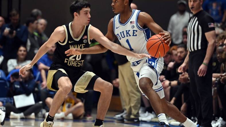 Feb 12, 2024; Durham, North Carolina, USA;  Duke Blue Devils guard Caleb Foster (1) controls the ball in front of Wake Forest Deamon Deacons guard Parker Friedrichsen (20) during the first half at Cameron Indoor Stadium. Mandatory Credit: Rob Kinnan-USA TODAY Sports