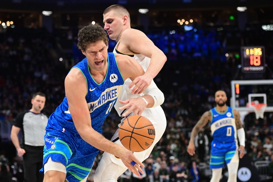 Feb 12, 2024; Milwaukee, Wisconsin, USA;  Milwaukee Bucks center Brook Lopez (11) tries to get past Denver Nuggets center Nikola Jokic (15) in the first quarter at Fiserv Forum. Mandatory Credit: Benny Sieu-USA TODAY Sports