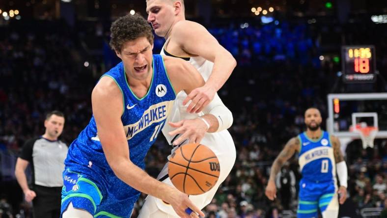 Feb 12, 2024; Milwaukee, Wisconsin, USA;  Milwaukee Bucks center Brook Lopez (11) tries to get past Denver Nuggets center Nikola Jokic (15) in the first quarter at Fiserv Forum. Mandatory Credit: Benny Sieu-USA TODAY Sports