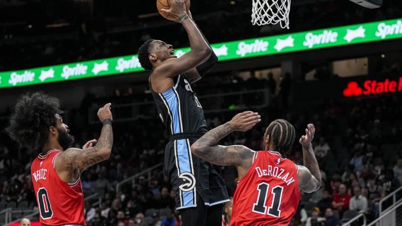 Feb 12, 2024; Atlanta, Georgia, USA; Atlanta Hawks forward Onyeka Okongwu (17) scores a basket over Chicago Bulls forward DeMar DeRozan (11) during the first half at State Farm Arena. Mandatory Credit: Dale Zanine-USA TODAY Sports