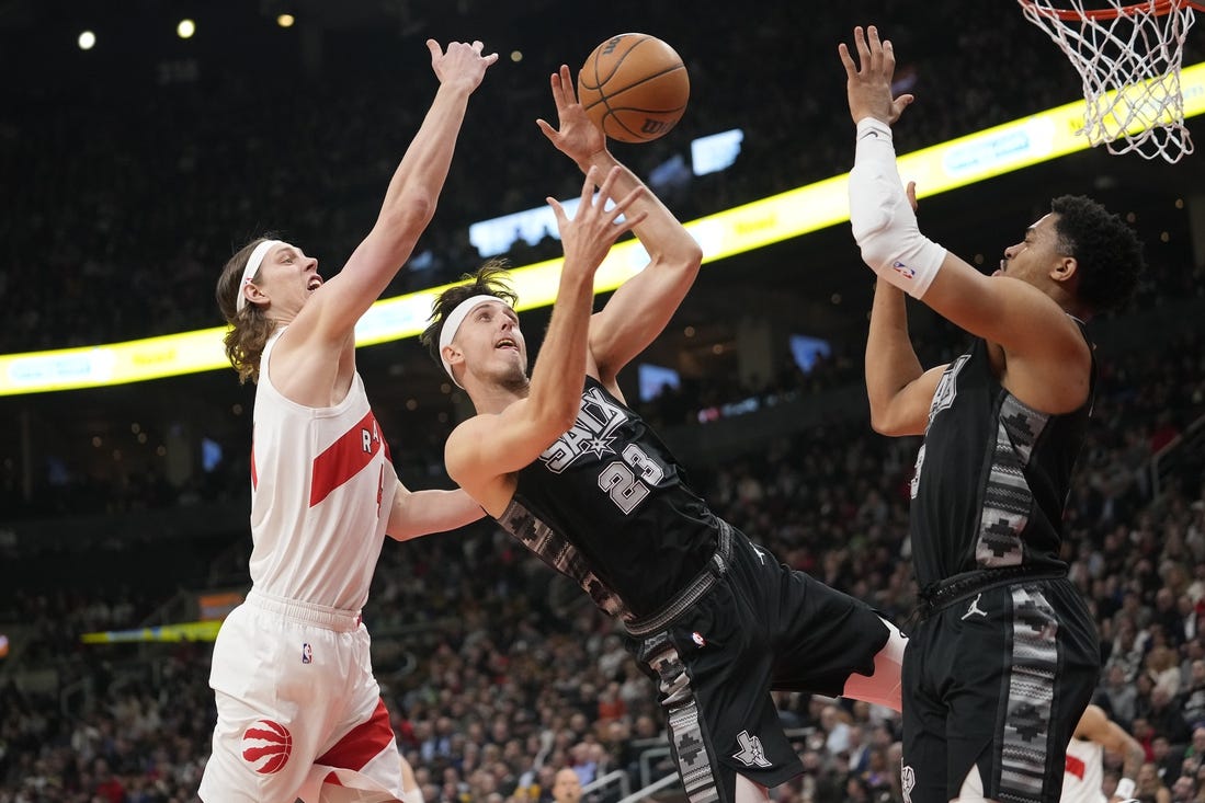 Feb 12, 2024; Toronto, Ontario, CAN; Toronto Raptors forward Kelly Olynyk (41) and San Antonio Spurs forward Zach Collins (23) and forward Keldon Johnson (3) battle for a rebound during the first half at Scotiabank Arena. Mandatory Credit: John E. Sokolowski-USA TODAY Sports