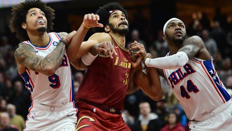 Feb 12, 2024; Cleveland, Ohio, USA; Cleveland Cavaliers center Jarrett Allen (31) fights for position against Philadelphia 76ers guard Kelly Oubre Jr. (9) and forward Paul Reed (44) during the second half at Rocket Mortgage FieldHouse. Mandatory Credit: Ken Blaze-USA TODAY Sports