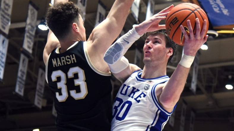 Feb 12, 2024; Durham, North Carolina, USA; Duke Blue Devils center Kyle Filipowski (30) shoots over Wake Forest Deamon Deacons center Matthew Marsh (33) during the second half at Cameron Indoor Stadium. The Blue Devils won 77-69. Mandatory Credit: Rob Kinnan-USA TODAY Sports