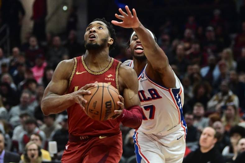 Feb 12, 2024; Cleveland, Ohio, USA; Cleveland Cavaliers guard Donovan Mitchell (45) drives to the basket against Philadelphia 76ers guard Buddy Hield (17) during the second half at Rocket Mortgage FieldHouse. Mandatory Credit: Ken Blaze-USA TODAY Sports