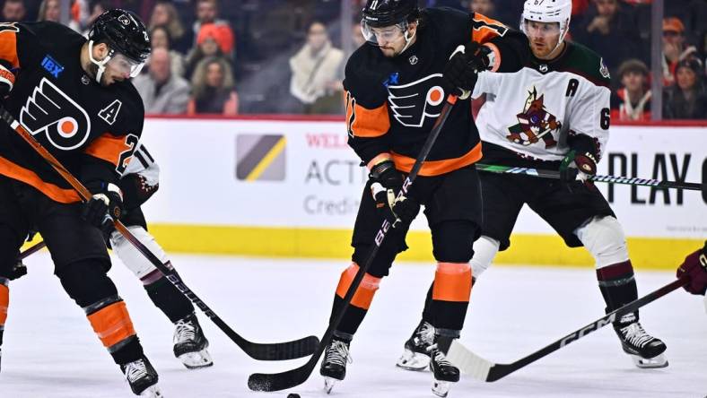 Feb 12, 2024; Philadelphia, Pennsylvania, USA; Philadelphia Flyers right wing Travis Konecny (11) reaches for a loose puck against the Arizona Coyotes in the third period at Wells Fargo Center. Mandatory Credit: Kyle Ross-USA TODAY Sports