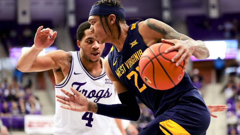 Feb 12, 2024; Fort Worth, Texas, USA;  West Virginia Mountaineers guard RaeQuan Battle (21) drives to the basket as TCU Horned Frogs guard Jameer Nelson Jr. (4) defends during the second half at Ed and Rae Schollmaier Arena. Mandatory Credit: Kevin Jairaj-USA TODAY Sports