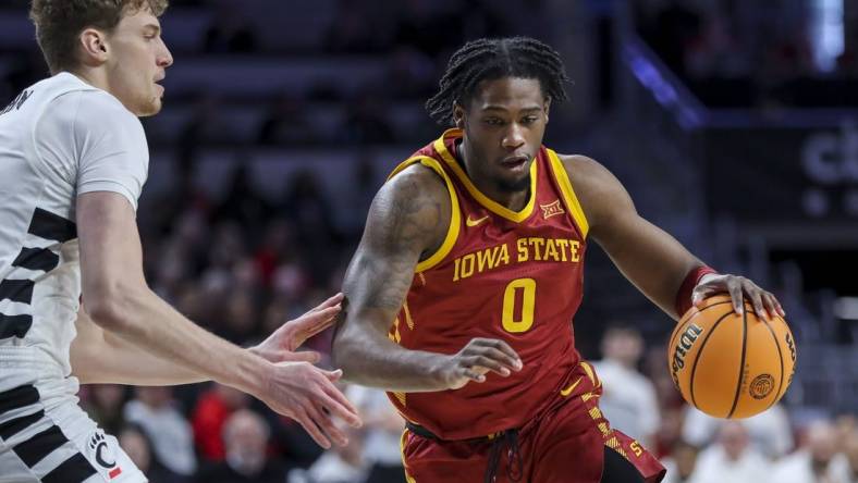 Feb 13, 2024; Cincinnati, Ohio, USA; Iowa State Cyclones forward Tre King (0) dribbles against Cincinnati Bearcats forward Viktor Lakhin (30) in the first half at Fifth Third Arena. Mandatory Credit: Katie Stratman-USA TODAY Sports