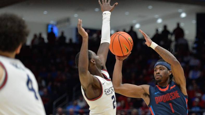 Feb 13, 2024; Dayton, Ohio, USA; Duquesne guard Jimmy Clark III (1) shoots the ball against Dayton Flyers guard Kobe Elvis (24) during the game at University of Dayton Arena. Mandatory Credit: Matt Lunsford-USA TODAY Sports