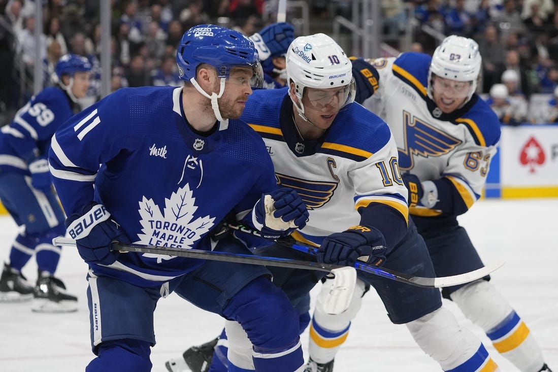 Feb 13, 2024; Toronto, Ontario, CAN; Toronto Maple Leafs forward Max Domi (11) and St. Louis Blues forward Brayden Schenn (10) battle for position during the second period Scotiabank Arena. Mandatory Credit: John E. Sokolowski-USA TODAY Sports