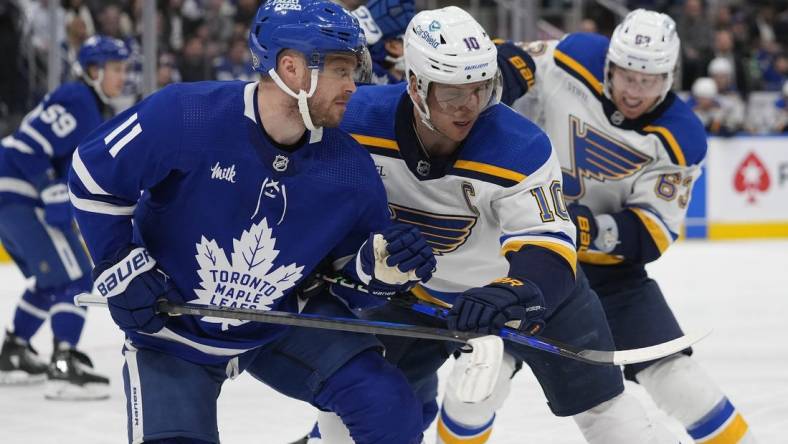 Feb 13, 2024; Toronto, Ontario, CAN; Toronto Maple Leafs forward Max Domi (11) and St. Louis Blues forward Brayden Schenn (10) battle for position during the second period Scotiabank Arena. Mandatory Credit: John E. Sokolowski-USA TODAY Sports