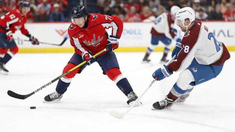 Feb 13, 2024; Washington, District of Columbia, USA; Washington Capitals right wing T.J. Oshie (77) controls the puck as Colorado Avalanche left wing Miles Wood (28) defends in the second period at Capital One Arena. Mandatory Credit: Geoff Burke-USA TODAY Sports