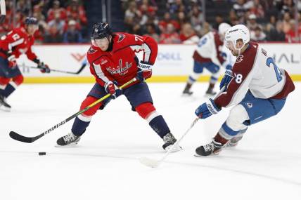 Feb 13, 2024; Washington, District of Columbia, USA; Washington Capitals right wing T.J. Oshie (77) controls the puck as Colorado Avalanche left wing Miles Wood (28) defends in the second period at Capital One Arena. Mandatory Credit: Geoff Burke-USA TODAY Sports
