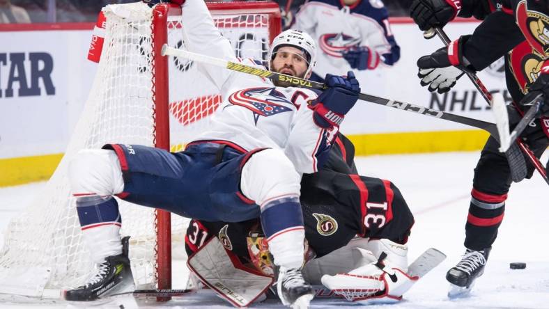 Feb 13, 2024; Ottawa, Ontario, CAN; Columbus Blue Jackets center Boone Jenner (38) falls on top of Ottawa Senators goalie Anton Forsberg (31)in a battle in the second period at the Canadian Tire Centre. Mandatory Credit: Marc DesRosiers-USA TODAY Sports