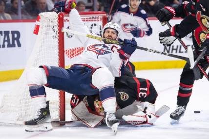 Feb 13, 2024; Ottawa, Ontario, CAN; Columbus Blue Jackets center Boone Jenner (38) falls on top of Ottawa Senators goalie Anton Forsberg (31)in a battle in the second period at the Canadian Tire Centre. Mandatory Credit: Marc DesRosiers-USA TODAY Sports