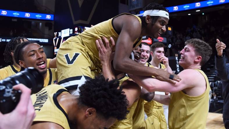 Feb 13, 2024; Nashville, Tennessee, USA; Vanderbilt Commodores guard Ezra Manjon (5) celebrates with teammates after making the game-winning basket against the Texas A&M Aggies at Memorial Gymnasium. Mandatory Credit: Christopher Hanewinckel-USA TODAY Sports