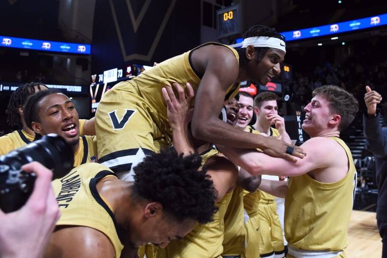 Feb 13, 2024; Nashville, Tennessee, USA; Vanderbilt Commodores guard Ezra Manjon (5) celebrates with teammates after making the game-winning basket against the Texas A&M Aggies at Memorial Gymnasium. Mandatory Credit: Christopher Hanewinckel-USA TODAY Sports