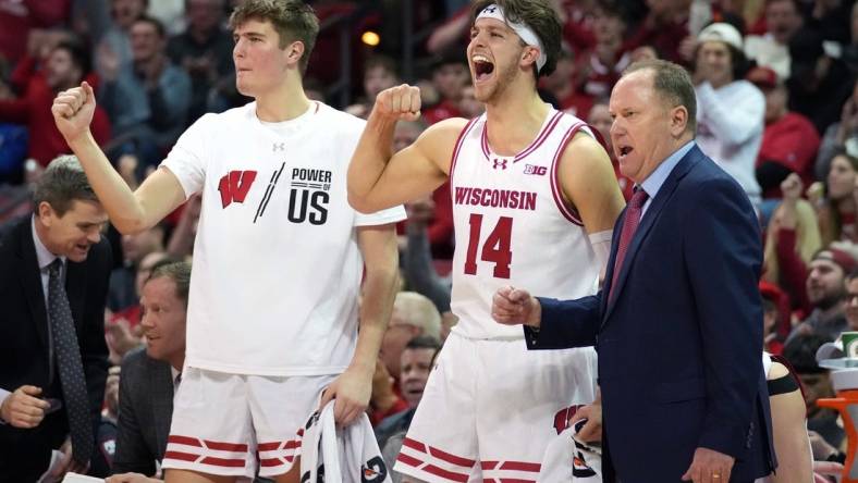 Feb 13, 2024; Madison, Wisconsin, USA;  Wisconsin Badgers forward Nolan Winter (31), forward Carter Gilmore (14) and head coach Greg Gard celebrate a three point basket during the second half against the Ohio State Buckeyes at the Kohl Center. Mandatory Credit: Kayla Wolf-USA TODAY Sports