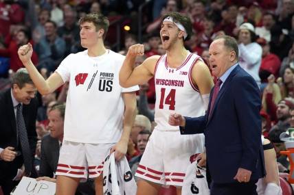 Feb 13, 2024; Madison, Wisconsin, USA;  Wisconsin Badgers forward Nolan Winter (31), forward Carter Gilmore (14) and head coach Greg Gard celebrate a three point basket during the second half against the Ohio State Buckeyes at the Kohl Center. Mandatory Credit: Kayla Wolf-USA TODAY Sports