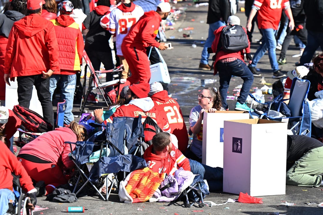 Feb 14, 2024; Kansas City, MO, USA; Fans shelter in place after shots were fired after the celebration of the Kansas City Chiefs winning Super Bowl LVIII. Mandatory Credit: David Rainey-USA TODAY Sports