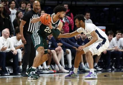 Feb 14, 2024; University Park, Pennsylvania, USA; Michigan State Spartans forward Malik Hall (25) holds the ball as Penn State Nittany Lions forward Zach Hicks (24) defends during the first half at Bryce Jordan Center. Mandatory Credit: Matthew O'Haren-USA TODAY Sports