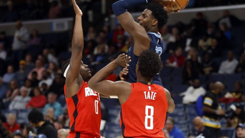 Feb 14, 2024; Memphis, Tennessee, USA; Memphis Grizzlies forward-center Jaren Jackson Jr. (13) passes the ball as Houston Rockets guard Aaron Holiday (0) and forward Jae'Sean Tate (8) defend during the first half at FedExForum. Mandatory Credit: Petre Thomas-USA TODAY Sports