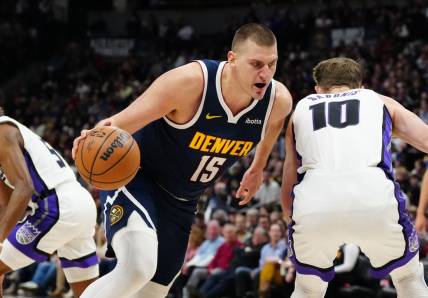 Feb 14, 2024; Denver, Colorado, USA; Denver Nuggets center Nikola Jokic (15) drives around Sacramento Kings forward Domantas Sabonis (10) in the first quarter at Ball Arena. Mandatory Credit: Ron Chenoy-USA TODAY Sports