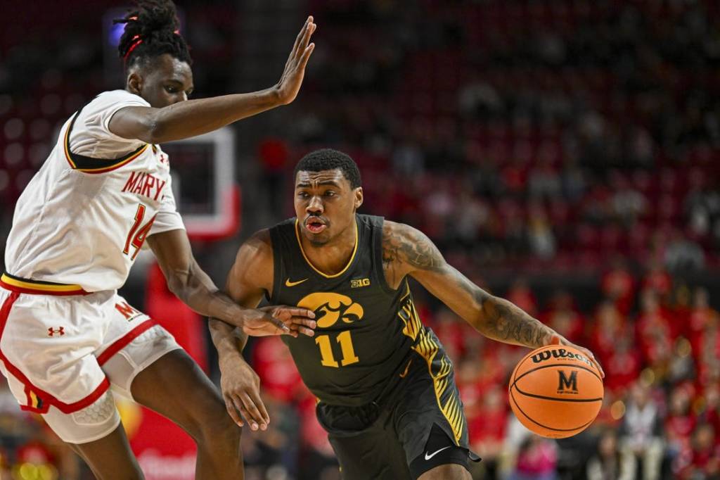 Feb 14, 2024; College Park, Maryland, USA;  Iowa Hawkeyes guard Tony Perkins (11) drive to the basket on Maryland Terrapins forward Mady Traore (14) during the fist half at Xfinity Center. Mandatory Credit: Tommy Gilligan-USA TODAY Sports