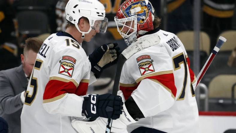 Feb 14, 2024; Pittsburgh, Pennsylvania, USA; Florida Panthers center Anton Lundell (15) and goaltender Sergei Bobrovsky (72) celebrate after defeating the Pittsburgh Penguins at PPG Paints Arena. Florida won 5-2.Mandatory Credit: Charles LeClaire-USA TODAY Sports