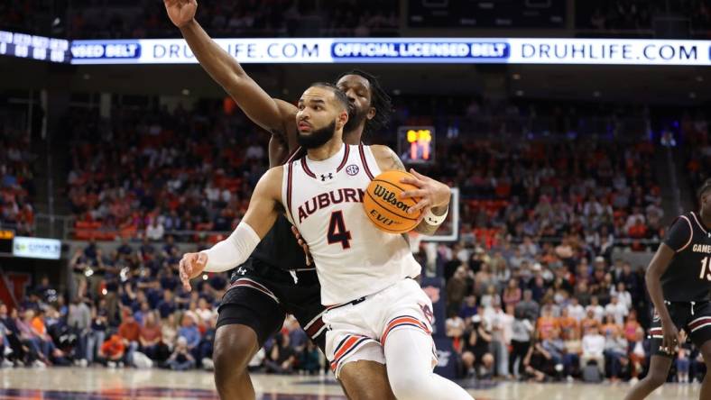 Feb 14, 2024; Auburn, Alabama, USA; Auburn Tigers forward Johni Broome (4) gets past South Carolina Gamecocks forward Josh Gray (33) for a shot during the second half at Neville Arena. Mandatory Credit: John Reed-USA TODAY Sports