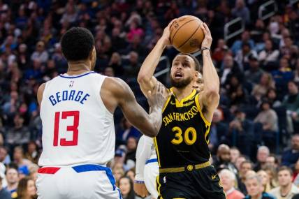 Feb 14, 2024; San Francisco, California, USA; Golden State Warriors guard Stephen Curry (30) passes over LA Clippers forward Paul George (13) during the first half at Chase Center. Mandatory Credit: John Hefti-USA TODAY Sports
