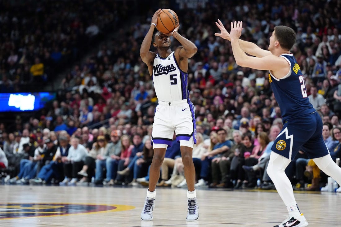 Feb 14, 2024; Denver, Colorado, USA; Sacramento Kings guard De'Aaron Fox (5) shoots the ball over Denver Nuggets guard Collin Gillespie (21) in the second half at Ball Arena. Mandatory Credit: Ron Chenoy-USA TODAY Sports