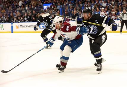 Feb 15, 2024; Tampa, Florida, USA; Tampa Bay Lightning center Steven Stamkos (91) and Colorado Avalanche defenseman Samuel Girard (49) skate after the puck during the first period at Amalie Arena. Mandatory Credit: Kim Klement Neitzel-USA TODAY Sports