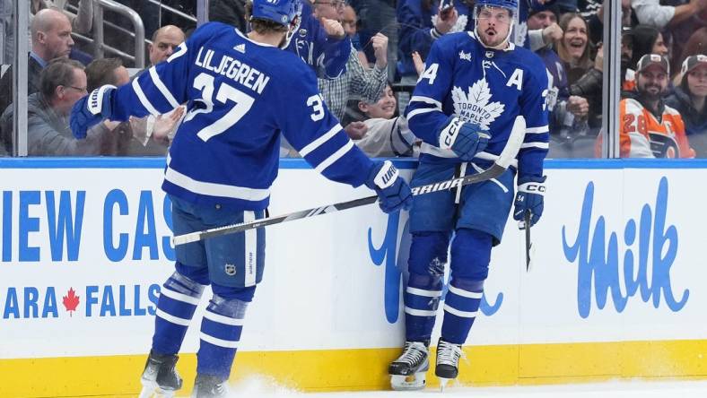 Feb 15, 2024; Toronto, Ontario, CAN; Toronto Maple Leafs center Auston Matthews (34) scores his first goal and celebrates with defenseman Timothy Liljegren (37) against the Philadelphia Flyers during the second period at Scotiabank Arena. Mandatory Credit: Nick Turchiaro-USA TODAY Sports