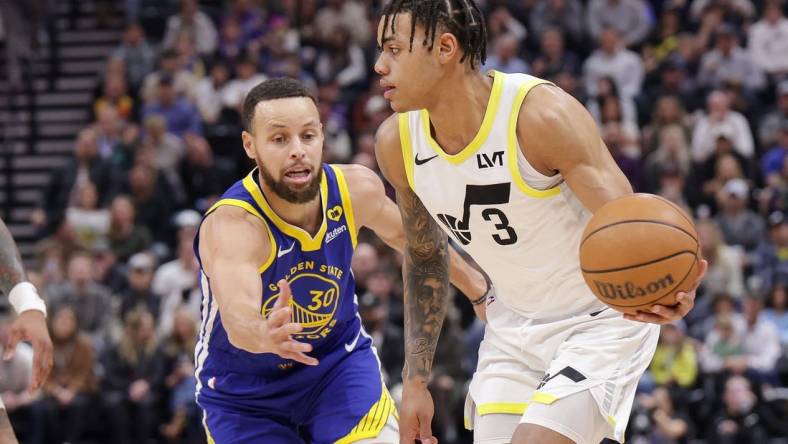 Feb 15, 2024; Salt Lake City, Utah, USA; Utah Jazz guard Keyonte George (3) keeps the ball away from Golden State Warriors guard Stephen Curry (30) during the first quarter at Delta Center. Mandatory Credit: Chris Nicoll-USA TODAY Sports