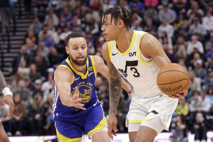 Feb 15, 2024; Salt Lake City, Utah, USA; Utah Jazz guard Keyonte George (3) keeps the ball away from Golden State Warriors guard Stephen Curry (30) during the first quarter at Delta Center. Mandatory Credit: Chris Nicoll-USA TODAY Sports