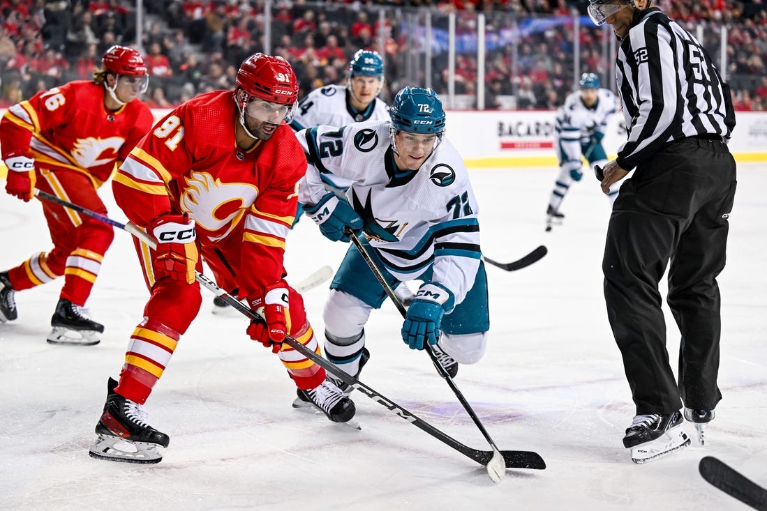 Feb 15, 2024; Calgary, Alberta, CAN; Calgary Flames center Nazem Kadri (91) and San Jose Sharks left wing William Eklund (72) take a face-off during the first period at Scotiabank Saddledome. Mandatory Credit: Brett Holmes-USA TODAY Sports