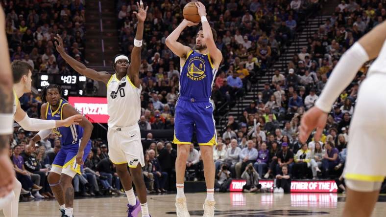 Feb 15, 2024; Salt Lake City, Utah, USA; Golden State Warriors guard Klay Thompson (11) shoots as Utah Jazz forward Taylor Hendricks (0) defends during the second half at Delta Center. Mandatory Credit: Chris Nicoll-USA TODAY Sports