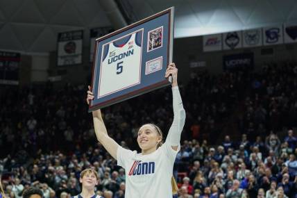 Feb 16, 2024; Storrs, Connecticut, USA; UConn Huskies guard Paige Bueckers (5) holds up her jersey during senior night after defeating the Georgetown Hoyas at Harry A. Gampel Pavilion. Mandatory Credit: David Butler II-USA TODAY Sports