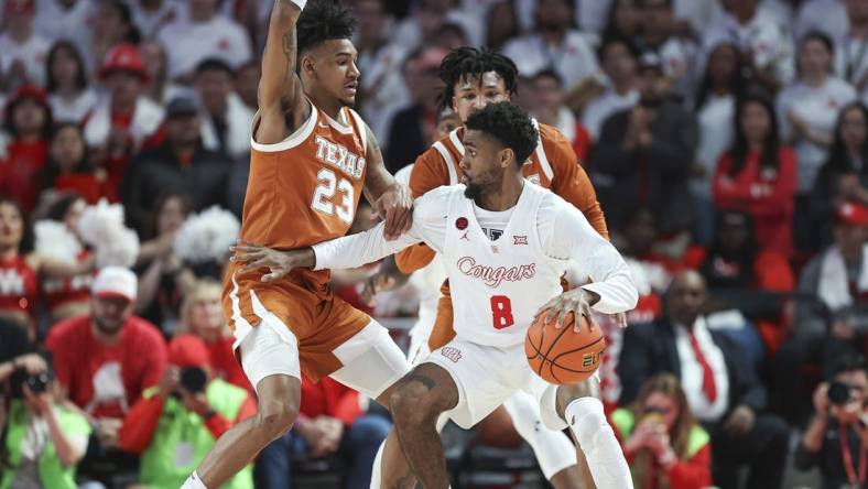 Feb 17, 2024; Houston, Texas, USA; Texas Longhorns forward Dillon Mitchell (23) defends against Houston Cougars guard Mylik Wilson (8) during the first half at Fertitta Center. Mandatory Credit: Troy Taormina-USA TODAY Sports