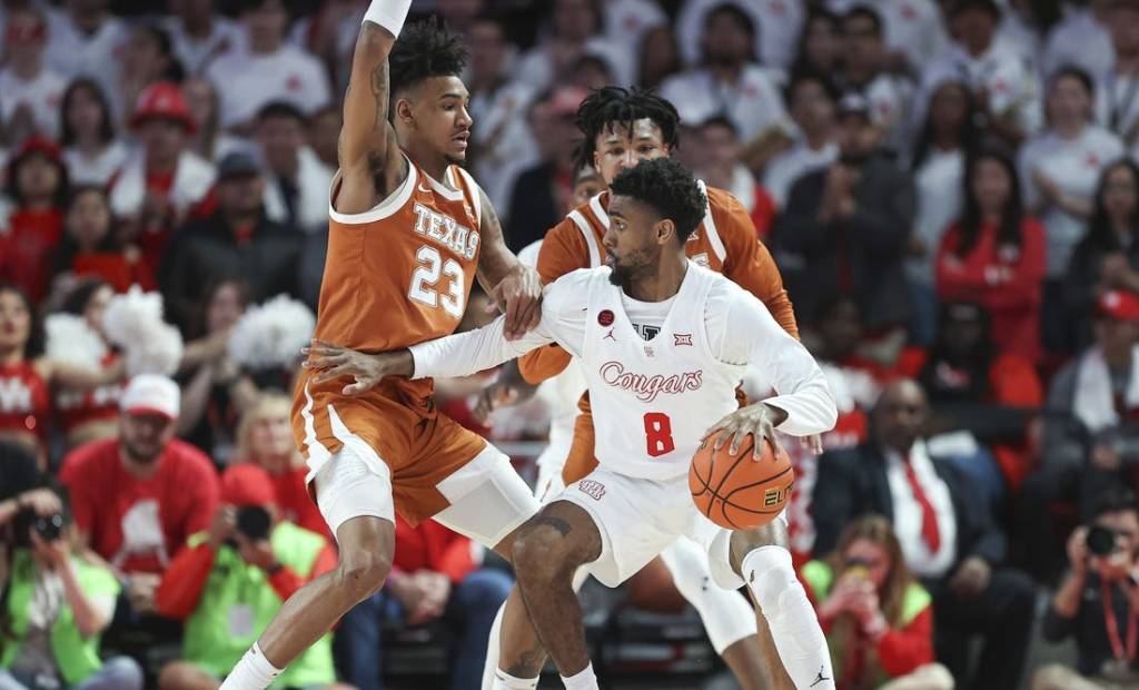 Feb 17, 2024; Houston, Texas, USA; Texas Longhorns forward Dillon Mitchell (23) defends against Houston Cougars guard Mylik Wilson (8) during the first half at Fertitta Center. Mandatory Credit: Troy Taormina-USA TODAY Sports