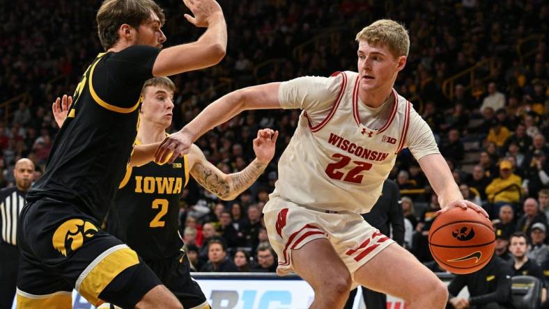 Feb 17, 2024; Iowa City, Iowa, USA; Wisconsin Badgers forward Steven Crowl (22) controls the ball as Iowa Hawkeyes forward Owen Freeman (32) and guard Brock Harding (2) defend during the first half at Carver-Hawkeye Arena. Mandatory Credit: Jeffrey Becker-USA TODAY Sports