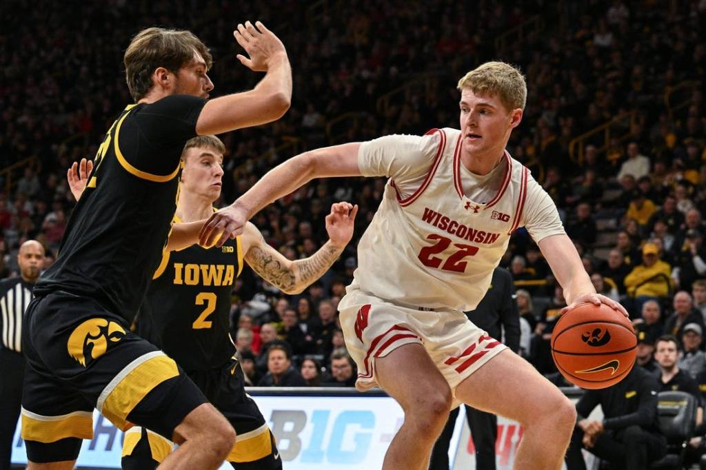 Feb 17, 2024; Iowa City, Iowa, USA; Wisconsin Badgers forward Steven Crowl (22) controls the ball as Iowa Hawkeyes forward Owen Freeman (32) and guard Brock Harding (2) defend during the first half at Carver-Hawkeye Arena. Mandatory Credit: Jeffrey Becker-USA TODAY Sports