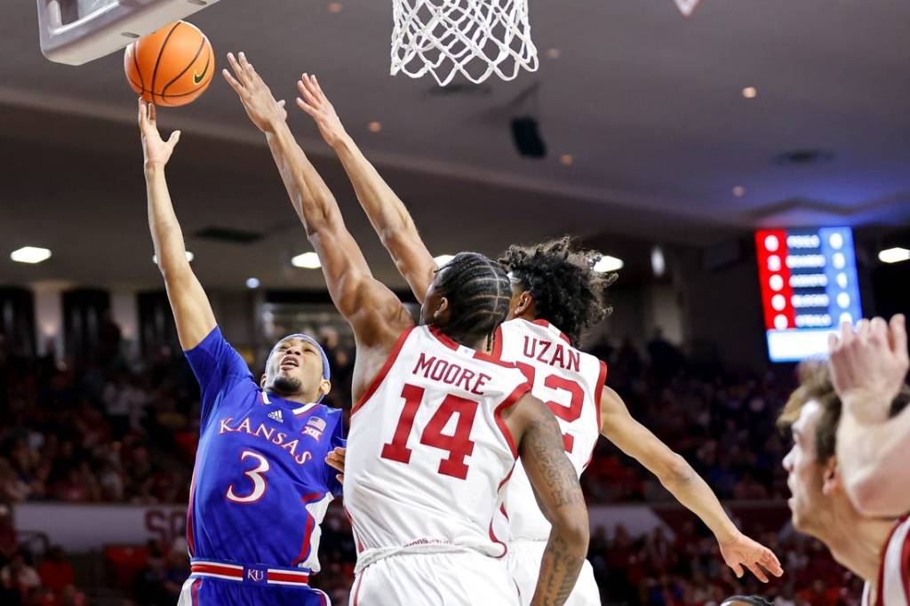 Kansas guard Dajuan Harris Jr. (3) lays up the ball past Oklahoma guard Milos Uzan (12) and Oklahoma forward Jalon Moore (14) in the first half during an NCAA basketball game between The University of Oklahoma (OU) and The University of Kansas (KU), at the Lloyd Noble Center in Norman Okla., on Saturday, Feb. 17, 2024.